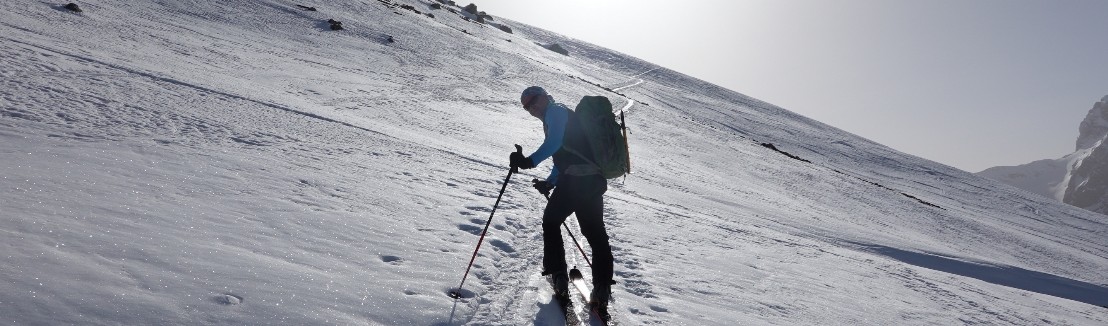 Ein Skitourenfahrer im Aufstieg in der gleissenden Sonne Richtung Naebelchaeppler.